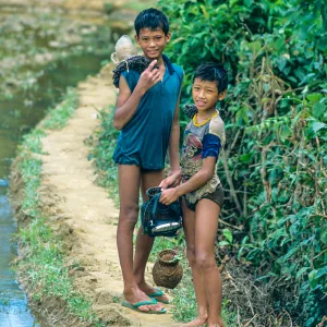 Laos. Chłopcy na grobli na ryżowisku w okolicy Vangvieng